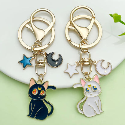 Sailor Moon–inspired enamel keychains featuring Luna or Artemis designs, made from zinc alloy with a smooth enamel finish, shown with individual and paired product images including size dimensions.