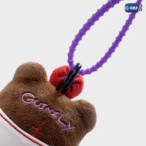 Close-up of the back of the Guinzly plush keychain, highlighting the plush fabric, colour details, and reinforced stitching.